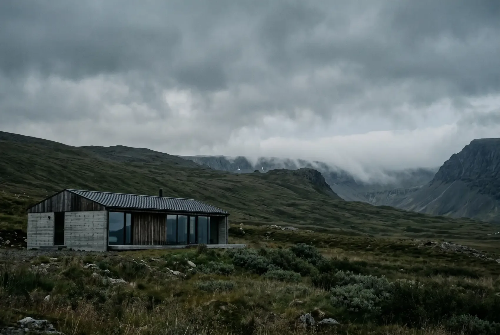 Architectural visualisation — the retreat under a wide moody sky, mist rolling across the ridge